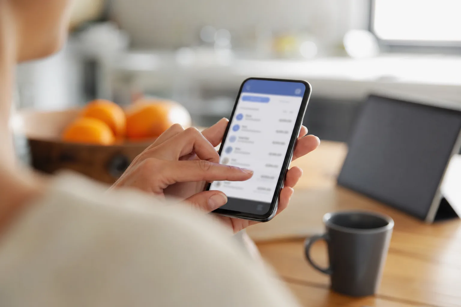 Personne consultant une application bancaire sur smartphone pour suivre un virement